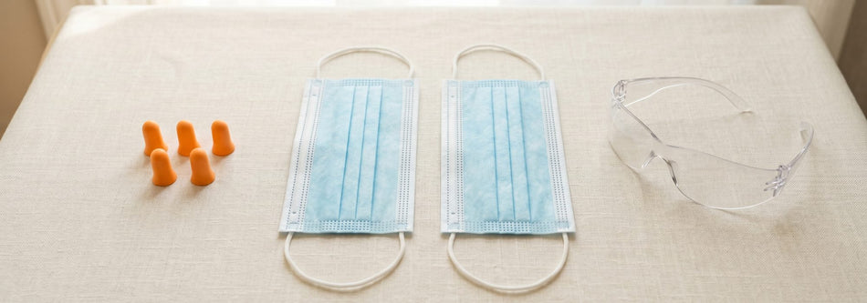 Disposable face masks, foam earplugs and clear safety glasses flat-lay